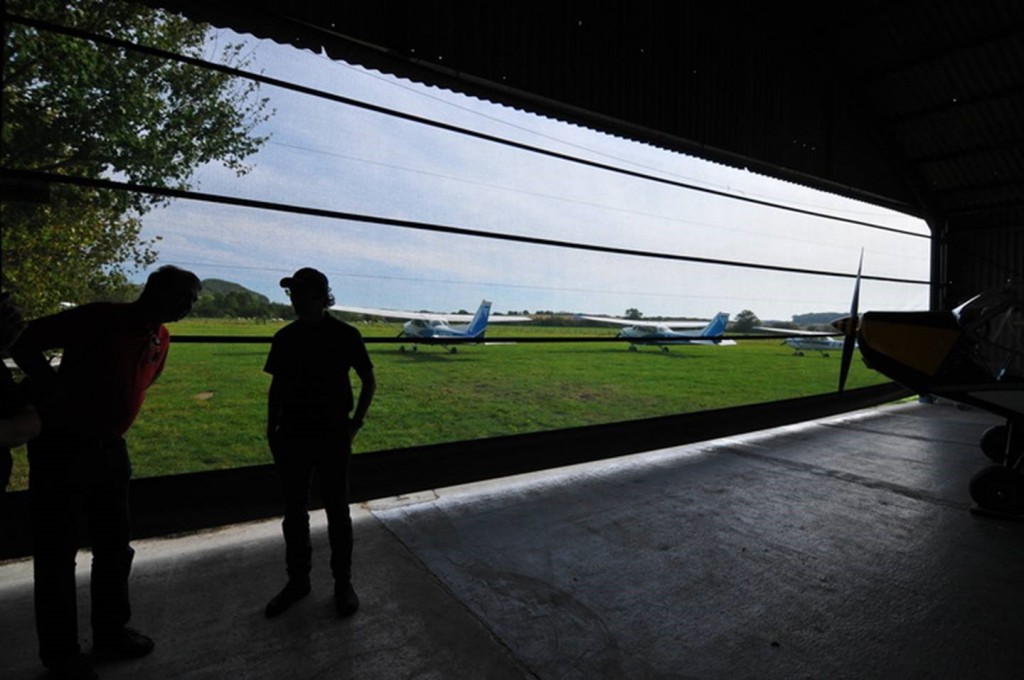 Farm Strips Fly Out Event - In Pent Farm's hangar with its innovative wind-breaking mesh door. Some of those earlier landings appear to have taken their toll on Red One's back.....